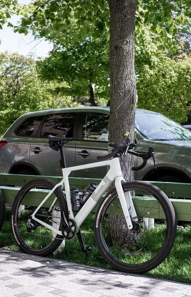 white carbon fiber frame bike parked on sidewalk