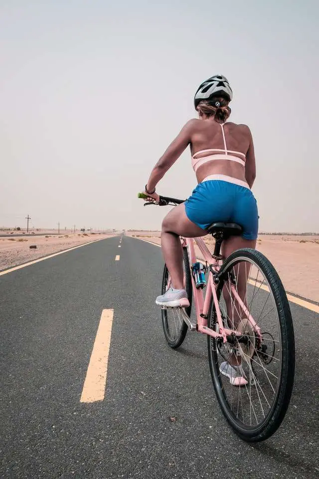 Female cyclist on pink bike on the open road