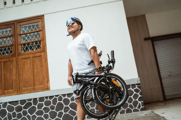 Male cyclist carrying foldable bike