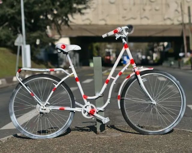 white and red polkadot painted bicycle on sidewalk