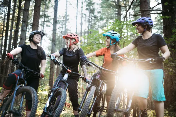 4 female mountain bikers having a chat on the trail