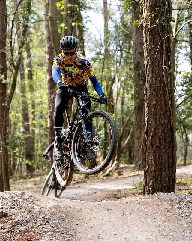 female mtb biker jumping over feature
