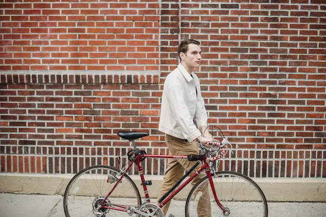man strolling with his bicycle with cable lock under seatpost