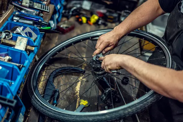 bike mechanic working on bicycle wheel