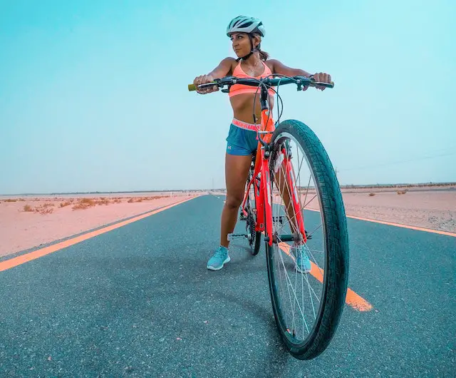 female athlete riding red mtb on road