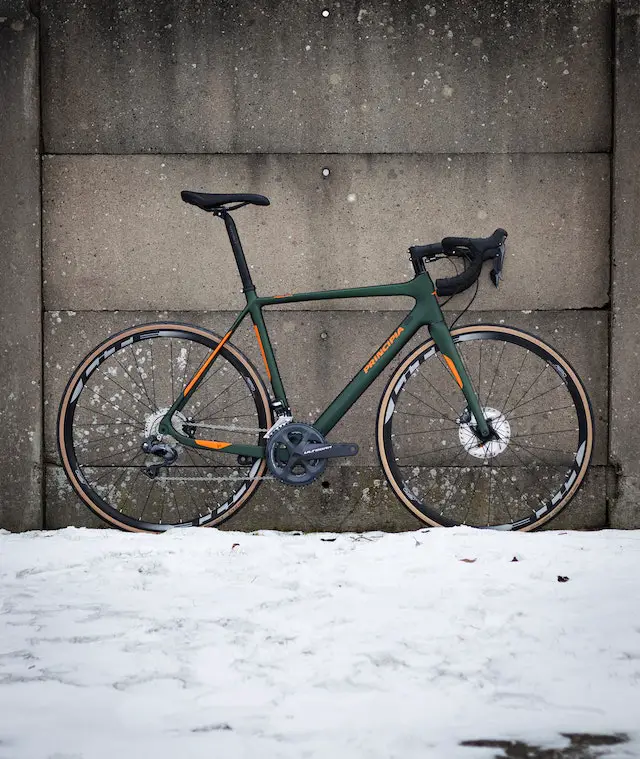 green racing bike against wall in winter