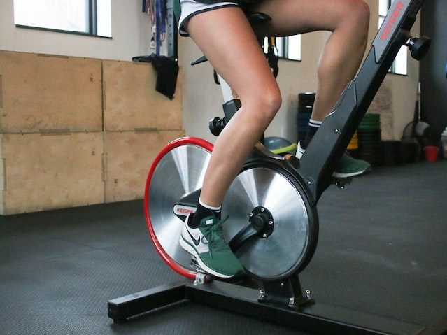 person exercising with stationary bike in gym
