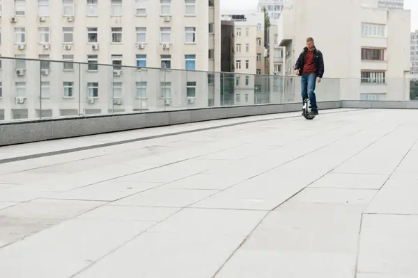 man riding euc on walkway