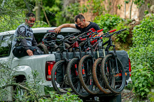 2 men with 5 mtbs in back of pickup truck