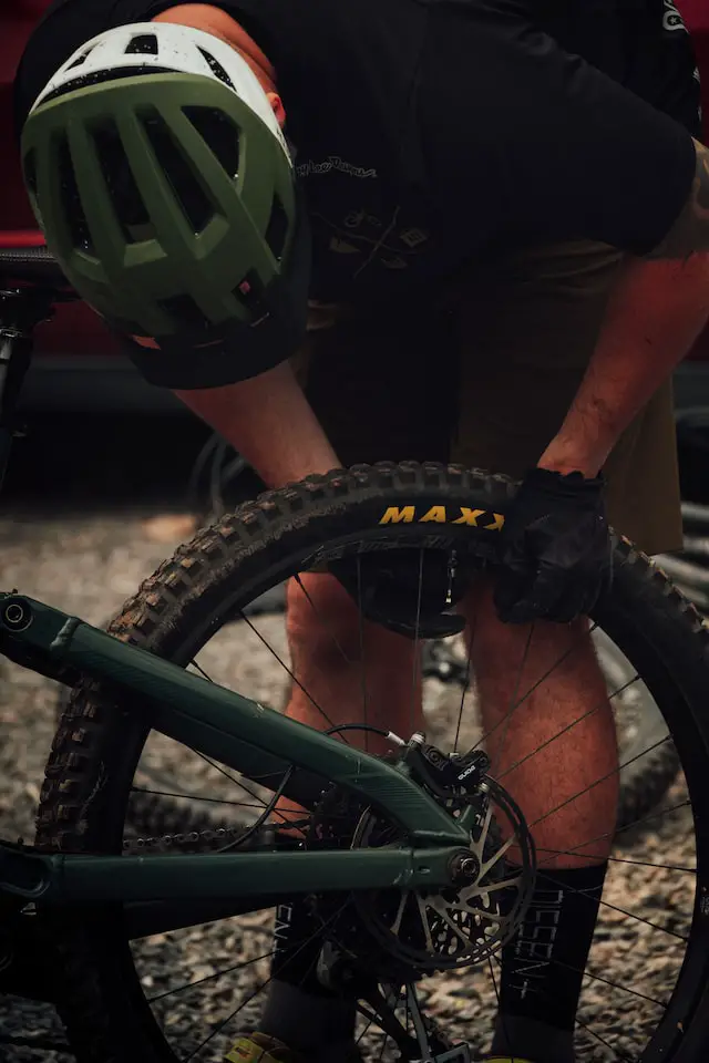 cyclist changing rear bike tire pressure